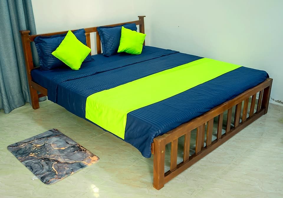 Double bed made up in navy linen with lime-green cushions